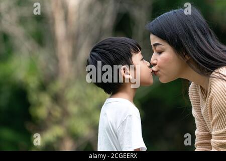 Ritratto bella mamma asiatica e il suo figlio carino baciarsi con amore mentre si guarda l'un l'altro, carino e caldo. Foto Stock