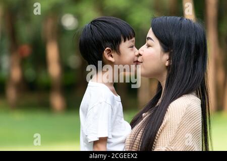 Ritratto bella mamma asiatica e il suo figlio carino baciarsi con amore mentre si guarda l'un l'altro, carino e caldo. Foto Stock