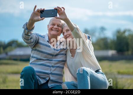 felice datazione di coppia senior, prendendo selfie e divertirsi all'aperto Foto Stock