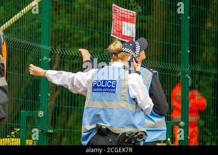 Denham, Buckinghamshire, Regno Unito. 8 Settembre 2020. Un giovane protettore dell'albero femmina scalò un albero questa mattina fuori dalla recinzione del composto HS2 che è, tuttavia, destinato ad essere tagliato da HS2. Era sotto stretta osservazione da parte degli agenti di applicazione della squadra nazionale di viction, degli ufficiali di Liaion della polizia e delle guardie di sicurezza di HS2. Il controverso collegamento HS2 High Speed Rail è impostato per danneggiare o distruggere 108 boschi antichi. Credito: Maureen McLean/Alamy Foto Stock