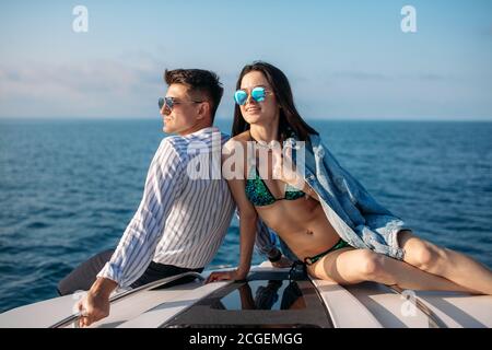 Giovane impiegato in abiti da ufficio casual sorpreso per la sua ragazza, ha noleggiato yacht motoscafo che fornisce loro un'atmosfera tranquilla e pri Foto Stock