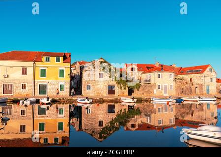 Argine del villaggio di Vrboska, le case si riflettono nell'acqua. Isola di Hvar, Croazia. Foto Stock