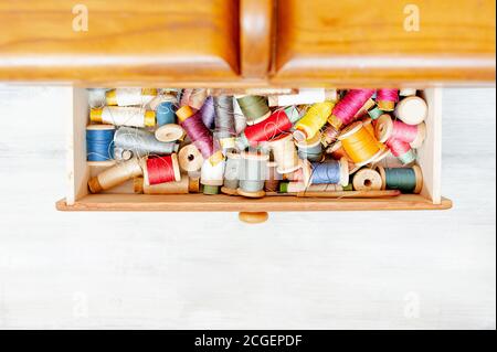 un sacco di palle colorate di filo in scatola di legno, attrezzi per cucire hobby, vista dall'alto Foto Stock