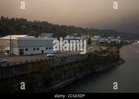 Cielo scuro con fumo da incendi di Riverside e Beachie Creek in lontananza, visto dall'Oregon City Bridge sul fiume Willamette al mattino. Foto Stock