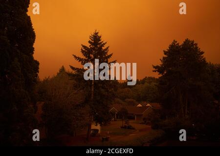 Cielo rosso fiero al crepuscolo con fumi provenienti da incendi di Riverside e Beachie Creek in lontananza, visto nel lago Oswego, Ore., Mercoledì 9 settembre 2020. Foto Stock