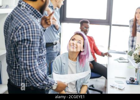 Giovani designer creativi multietnici al lavoro in un ufficio internazionale. Spazio di lusso, pieno di luce naturale e sole. Foto Stock