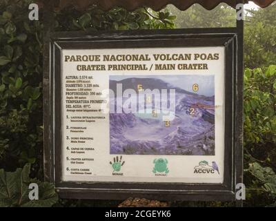 Provincia di Alajuela, Costa Rica - 28 novembre 2008: Segno esplicativo del Parco Nazionale Vulcano Poas in legno nero cornice con verde scuro fogliame in bac Foto Stock