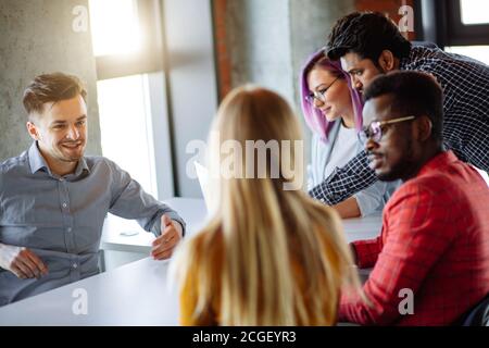 Ben noto designer femmina con viola i capelli tinti in visita azienda di giovani designer. La gente di affari di diverse gare di riunione in ufficio moderno a d Foto Stock
