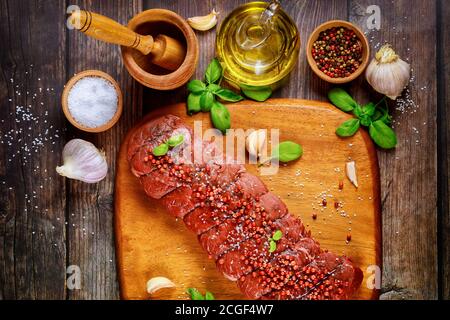 Pezzo crudo di bistecca di manzo con spezie e olio. Vista dall'alto. Foto Stock