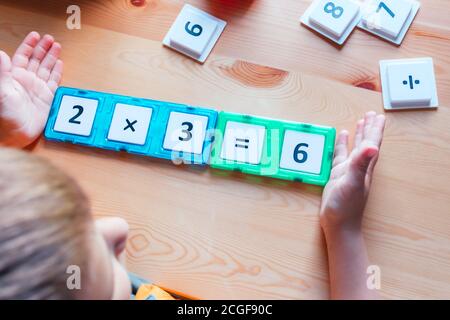 Boy tiene un progettista magnetico con numeri e formula Foto Stock