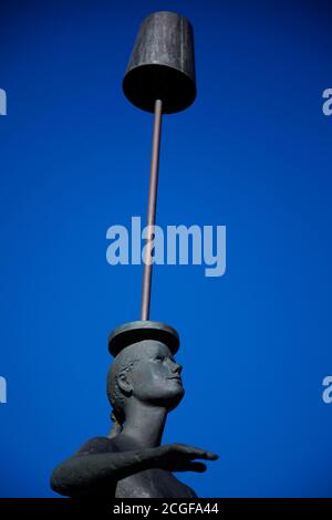 Skelleftea, Norrland Svezia - 3 agosto 2020: Donna che bilancia la lampada sulla testa come una statua Foto Stock