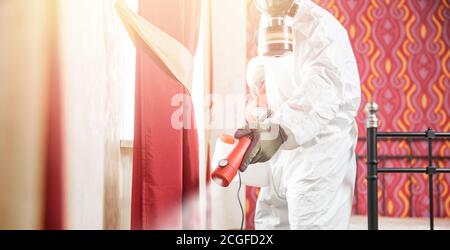 Specialista operaio in bianco Hazmat tute pulizia disinfettante cellule coronavirus epidemia, chiaro virus casa pandemia Foto Stock