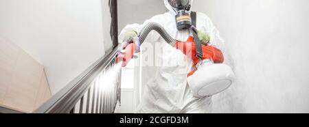 Specialista operaio in bianco Hazmat tute pulizia disinfettante cellule coronavirus epidemia, chiaro virus casa pandemia Foto Stock