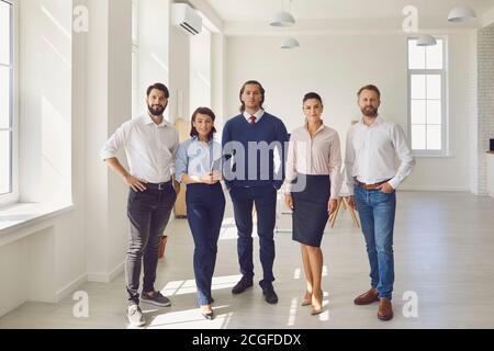 Ritratto degli allenatori d'affari con gli impiegati che guardano la macchina fotografica nell'ufficio del centro di affari. Foto Stock