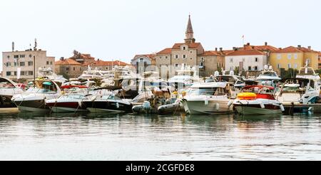 Marina per yacht a vela e barche che si affacciano sulla città vecchia al largo della costa di Budva, Montenegro. Foto Stock