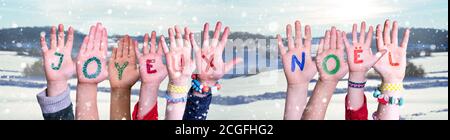 Le mani dei bambini, Joyeux Noel significa buon Natale, innevato sfondo invernale Foto Stock