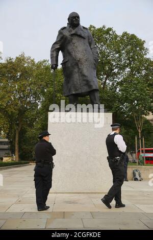 RITRASMESSO CORREGGENDO GLI ufficiali di polizia DI BYLINE dalla statua di Winston Churchill in Piazza del Parlamento, Londra, dopo che è stato vandalizzato durante l'ultimo giorno delle dimostrazioni di ribellione di estinzione il giovedì. Foto Stock