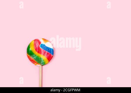 Un grande lollipop rotondo multicolore su sfondo rosa Foto Stock