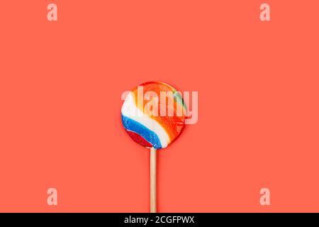 Un grande lollipop rotondo multicolore su sfondo arancione Foto Stock