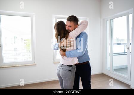 Una coppia di famiglie eccitate che si agganata a New House Foto Stock