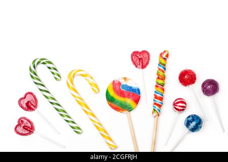 Lollipos assortiti e canne caramelle su uno sfondo bianco in una vista dall'alto Foto Stock