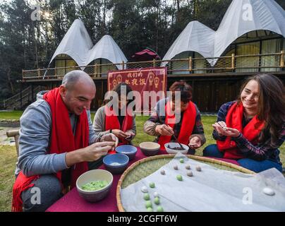 (200911) -- HANGZHOU, 11 settembre 2020 (Xinhua) -- studenti stranieri fanno Tangyuan, o gnocchi dolci, con un locale in una famiglia nel distretto di Lin'an di Hangzhou, nella provincia di Zhejiang della Cina orientale, 22 gennaio 2019. Negli ultimi 15 anni, guidati dalla convinzione che 'acque lucide e montagne lussureggianti sono beni inestimabili', un gran numero di villaggi nella provincia di Zhejiang hanno subito trasformazioni ambientali, attirando investimenti di capitale di ritorno alla campagna e stimolando lo sviluppo del turismo in famiglia. Come pioniere ed esploratore nello sviluppo del commercio di famiglia in Cina, Zhej Foto Stock