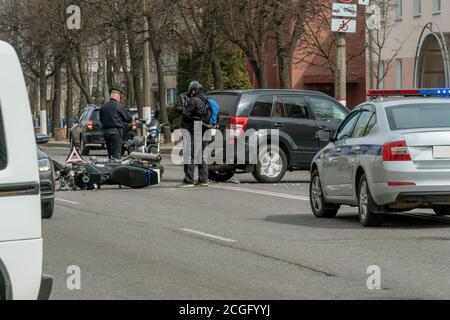 Incidente in città: Una moto rotta e una macchina. Registrazione di un incidente stradale. Ingorghi di traffico dovuto un incidente, macchina di polizia, polizia, persone Foto Stock