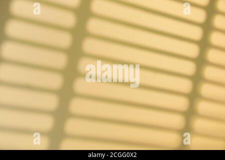 Effetto di sovrapposizione delle ombre. Ombre di cornici di finestre, barre e linee sulla parete alla luce del sole. Luce solare soffusa Foto Stock