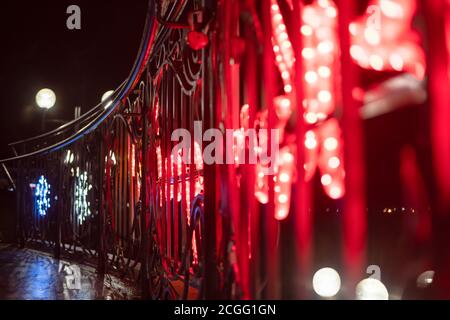 Scale decorate con luci rosse di Natale su una notte invernale sulla strada della città. Concetto di decorazione della città per le vacanze Foto Stock