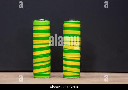 Due batterie giallo-verde, primo piano su sfondo nero. Spazio per il testo Foto Stock