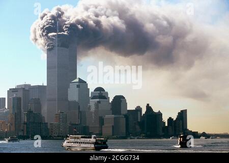 Dalle torri del World Trade Center nel quartiere di New York di Manhattan emerge un fumo nero intenso la mattina del 11 settembre 2001. Poco prima, due aerei avevano corso uno dietro l'altro nelle due torri. Oltre agli occupanti delle macchine, la maggior parte delle persone all'interno dei due grattacieli sono state uccise nelle pesanti esplosioni. L'FBI si fa sospettare che si tratti di un attacco mirato da parte di terroristi kamikaze. Le parti superiori dei grattacieli salirono in fiamme dopo le esplosioni. Parti del relitto e gli edifici delle torri gemelle alte 411 metri volarono sulla strada. Th Foto Stock