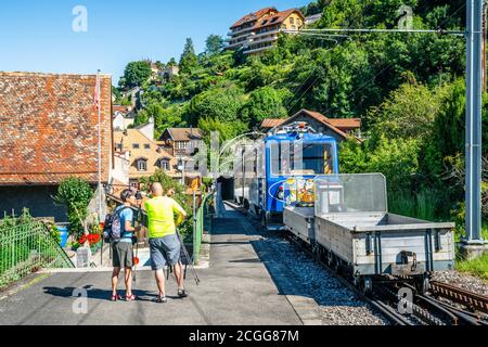 Montreux Svizzera , 5 luglio 2020 : treno Cog che va a Rochers-de-Naye e due escursionisti turisti nella città vecchia di Montreux Svizzera Foto Stock