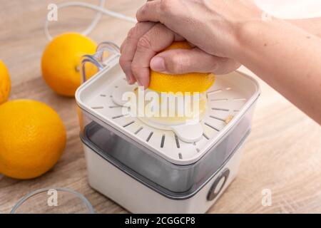 Donna spremitura arance in cucina Foto Stock