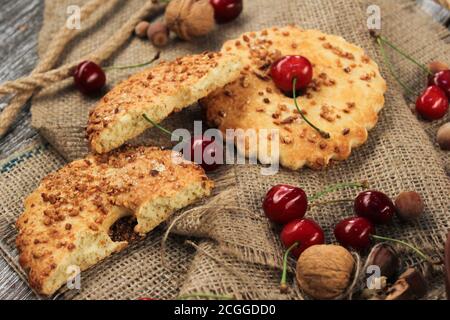 Biscotti con noci e ciliegie su sfondo rustico Foto Stock