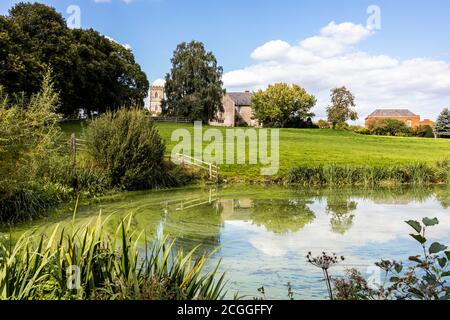 Maisemore Court e la chiesa di St Giles si affacciano sul lago nel villaggio di Severn vale a Maisemore, Gloucestershire UK Foto Stock