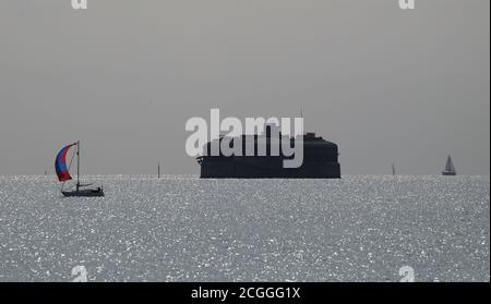 Una barca a vela passa il forte di Horse Sand nel Solent. . Foto Stock