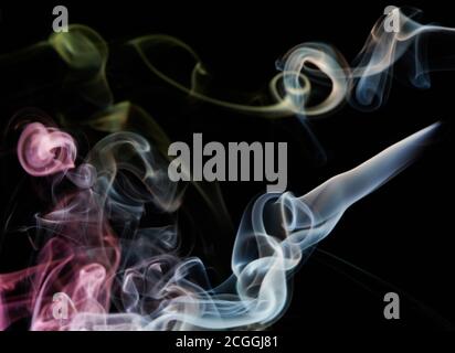 Il fumo colorato e riccamente trasparente ruota su sfondo nero Foto Stock