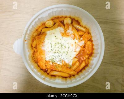 Tteok-bokki, o torte di riso saltate in padella - popolari piatti coreani fatti da torta di riso di piccole dimensioni, torta di pesce e uova sode. Condito con mozzarella. Foto Stock