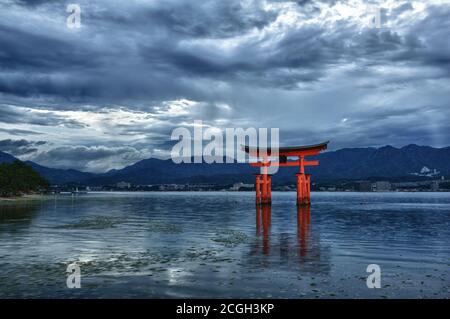 Grande porta galleggiante (o-Torii) sull'isola di Miyajima vicino al santuario di Itsukushima shinto, Giappone poco dopo il tramonto Foto Stock