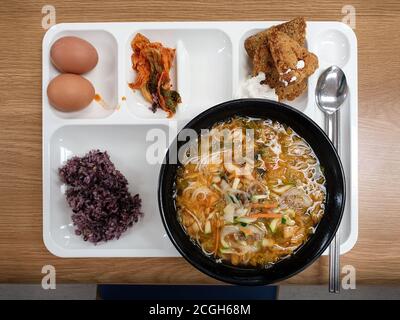 Menu pranzo della caffetteria dipendente in Corea del Sud. Vari menu nel vassoio cibo Janchi-guksu, o noodle banchetti. Cotoletta di pesce con salsa tartara. Foto Stock