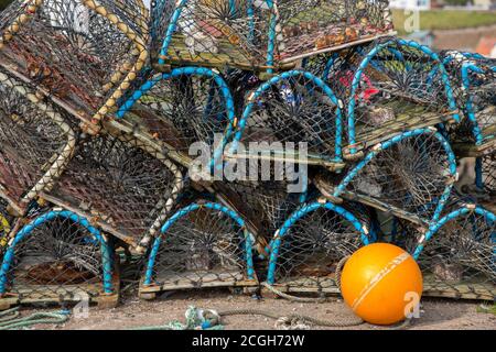 Pentole di aragosta su un lato di banchina in attesa di essere caricato su una barca da pesca Foto Stock