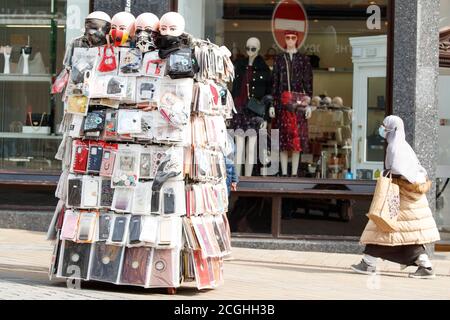 Uno shopper indossa una maschera facciale nel centro di Leeds, West Yorkshire, dove misure di blocco più severe possono essere introdotte localmente dopo un aumento delle infezioni da coronavirus. Foto Stock