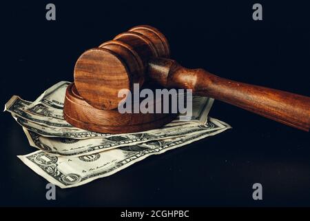 Gavel del giudice del legno sulla closeup delle banconote del dollaro degli Stati Uniti. Concetto di corruzione della giustizia Foto Stock