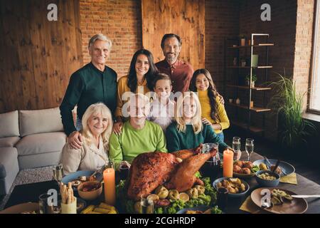 Ritratto di simpatico adorabile famiglia allegro bambini piccoli incontro godendo di celebrazione tradizione abbracciando mangiare tacchino domestico al moderno Foto Stock