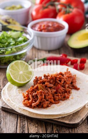 Tacos messicani ingredienti su tavolo di legno Foto Stock