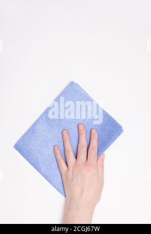 Parte della mano con un panno blu per spolverare e rimuovere lo sporco. Pulizia, sfondo bianco, spazio libero per il testo. Foto Stock