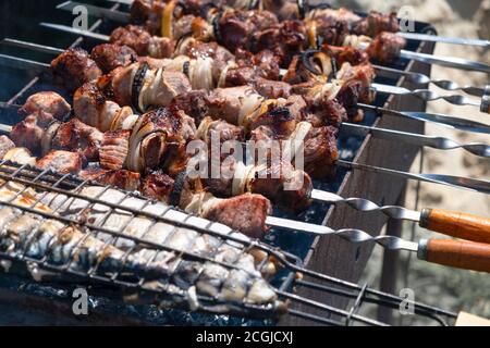 Pesce e maiale shish kebab arrostire su uno strung bracier su uno spiedino Foto Stock