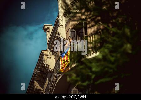 Barcellona, Spagna. 11 Settembre 2020. Una donna guarda l'atto principale dell'ANC dal suo balcone durante la 'Diadaa' (Giornata Nazionale Catalana) a Barcellona. A causa della crisi della corona, la partecipazione di quest'anno alla Diada è molto più bassa per prevenire la diffusione del virus. Credit: Matthias Oesterle/Alamy Live News Foto Stock