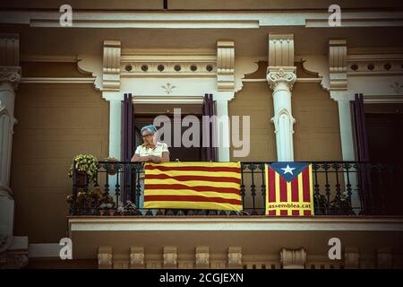 Barcellona, Spagna. 11 Settembre 2020. Una donna guarda l'atto principale dell'ANC dal suo balcone durante la 'Diadaa' (Giornata Nazionale Catalana) a Barcellona. A causa della crisi della corona, la partecipazione di quest'anno alla Diada è molto più bassa per prevenire la diffusione del virus. Credit: Matthias Oesterle/Alamy Live News Foto Stock