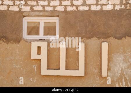 'Allah' scritto su un muro nel borgo medievale di fango Sahariana di al Qasr, nell'Oasi di Dakhla, nel deserto occidentale del Sahara, Nuova Valle, Egitto. Foto Stock